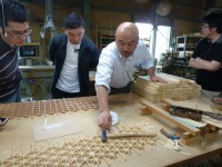 組子を組んでいる製造工程を説明している谷端信夫社長
